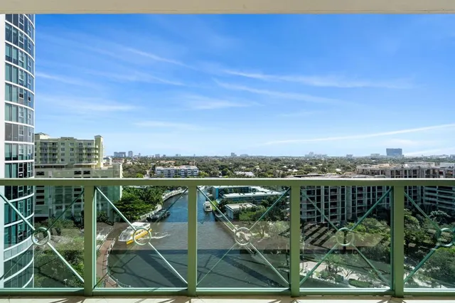 a view of a city from a balcony with chairs