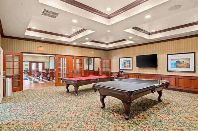 a living room with pool table and a flat screen tv