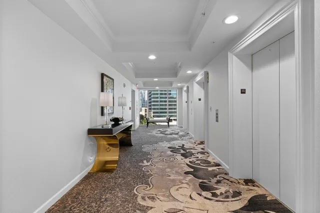 a view of a hallway with wooden floor and furniture