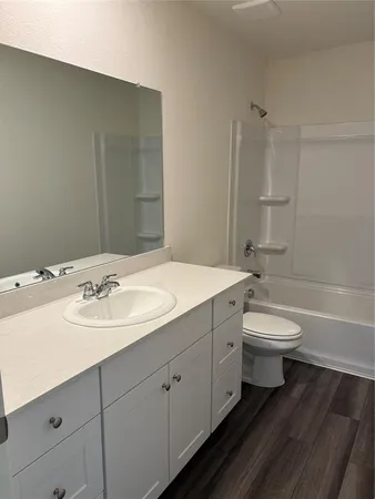 a bathroom with a toilet a sink a mirror and a bathtub