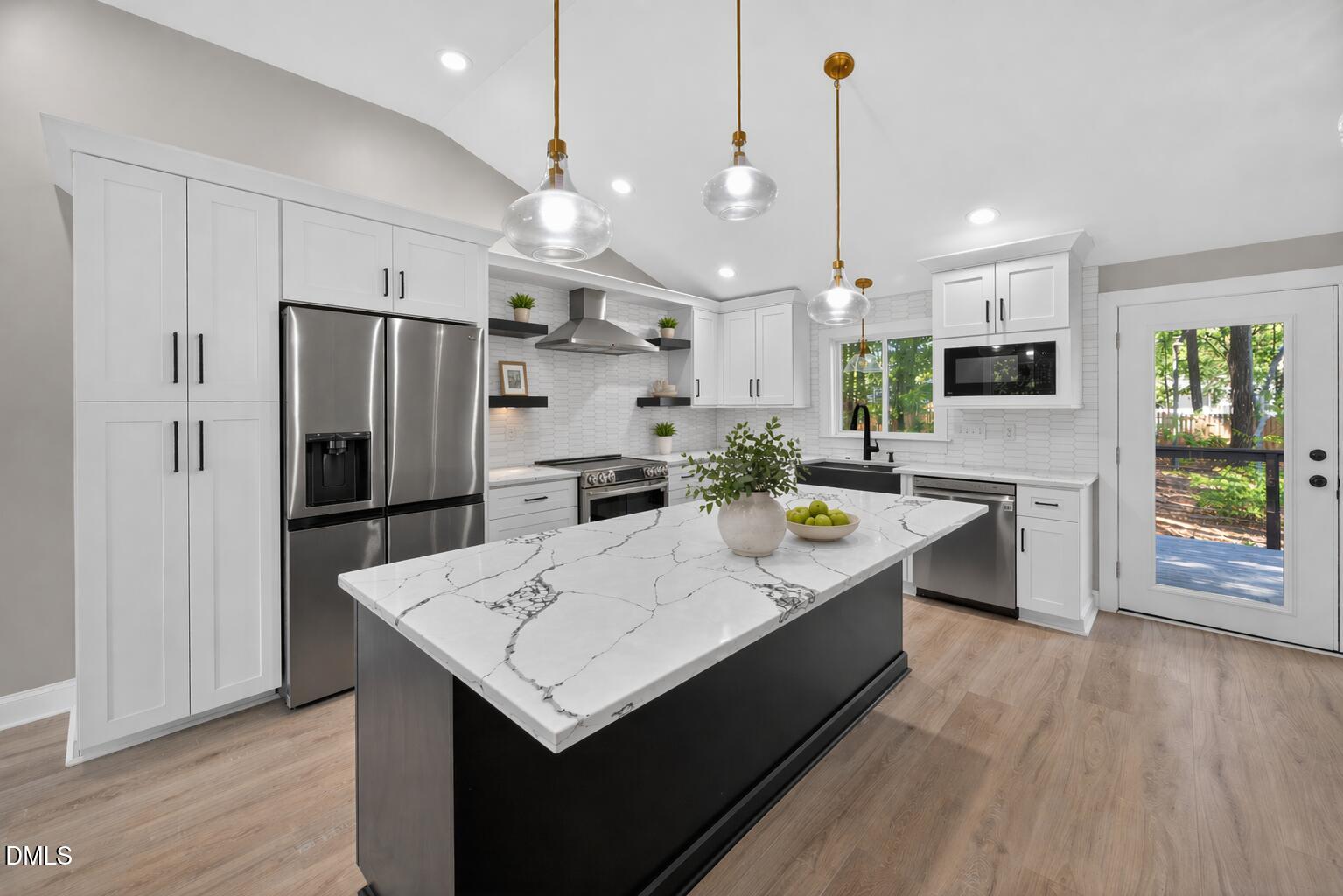 313 Crown Oaks Drive Raleigh, NC 27615 - Photo 11 of 60 a large kitchen with kitchen island a refrigerator a stove a sink a dining table and chairs