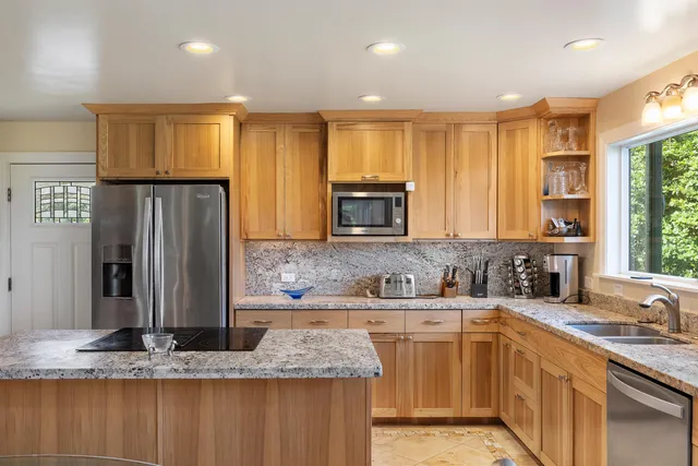 a kitchen with stainless steel appliances granite countertop a sink stove and refrigerator