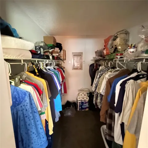 a view of walk in closet with clothes and shoes