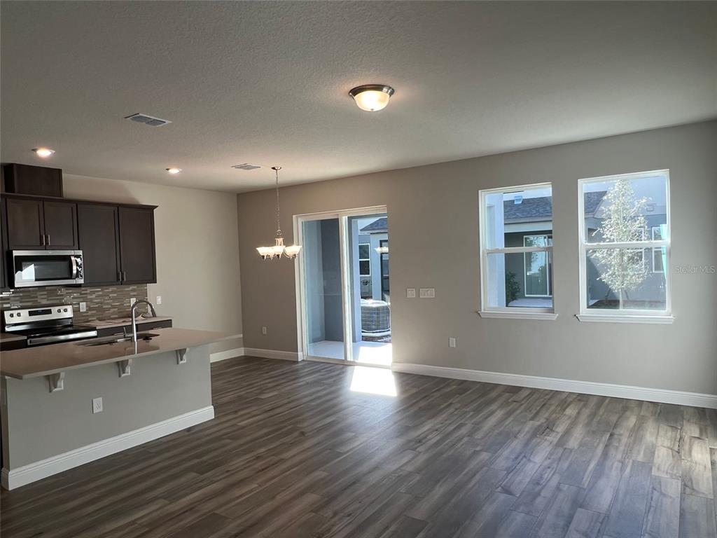 2232 Shadowland Loop Winter Park, FL 32792 - Photo 4 of 12 a large kitchen with stainless steel appliances granite countertop a large stove a sink dishwasher and a microwave oven with wooden floor