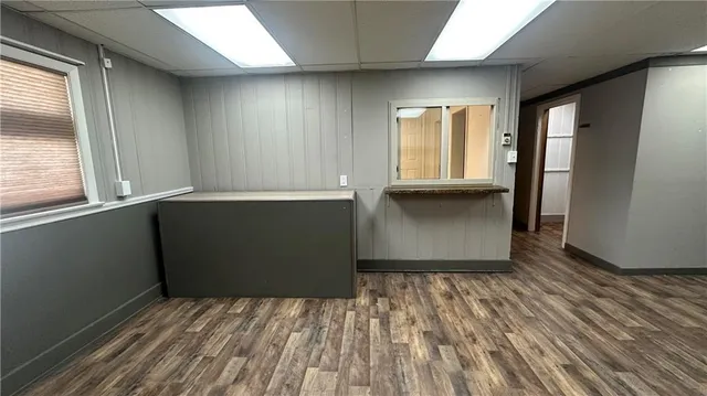 a view of empty room with window and wooden floor
