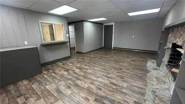 a view of an empty room with window and wooden floor