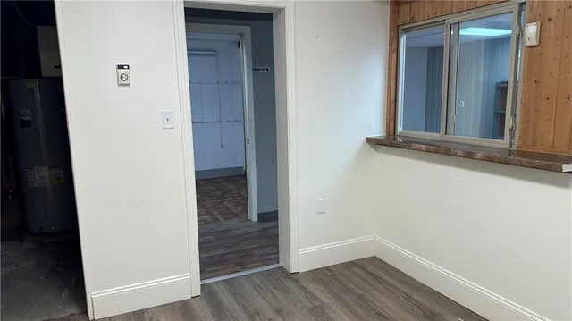 an empty room with wooden floor and entrance