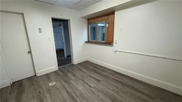 a view of a room with wooden floor and a window