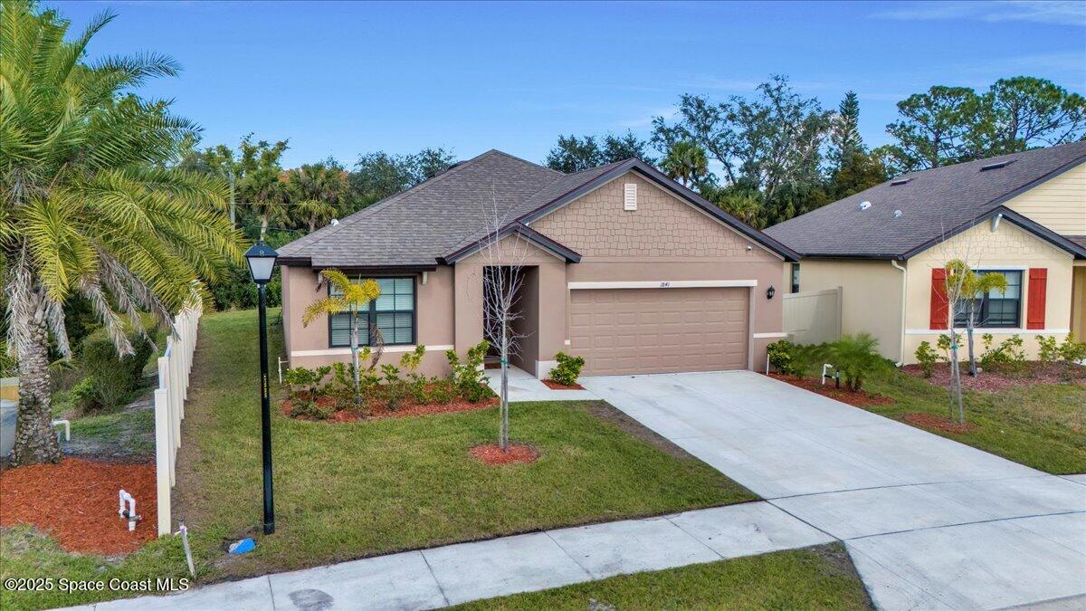1841 Saxton Road Cocoa, FL 32926 - Photo 2 of 45 a front view of a house with a yard and garage