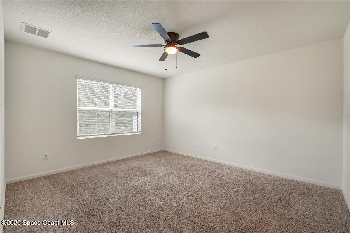 1841 Saxton Road Cocoa, FL 32926 - Photo 25 of 45 an empty room with ceiling fan and window