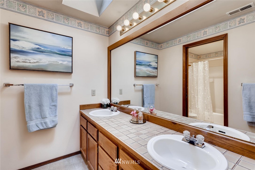 1908 233rd Place Southeast Bothell, WA 98021 - Photo 12 of 24 a bathroom with a granite countertop sink a large mirror and a shower
