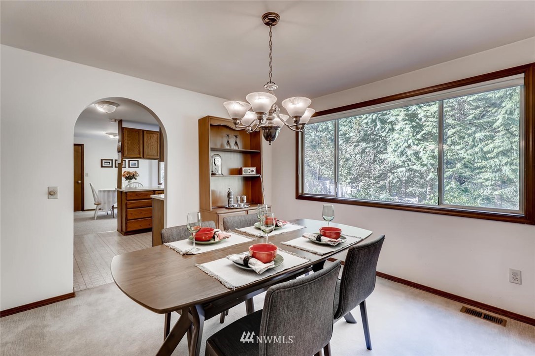 1908 233rd Place Southeast Bothell, WA 98021 - Photo 5 of 24 a dining room with furniture a large window and a chandelier