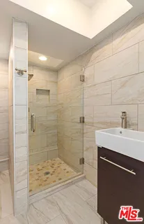 a bathroom with a sink shower and a mirror