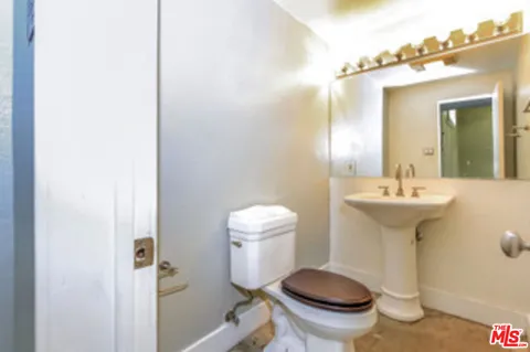 a bathroom with a sink toilet and a mirror