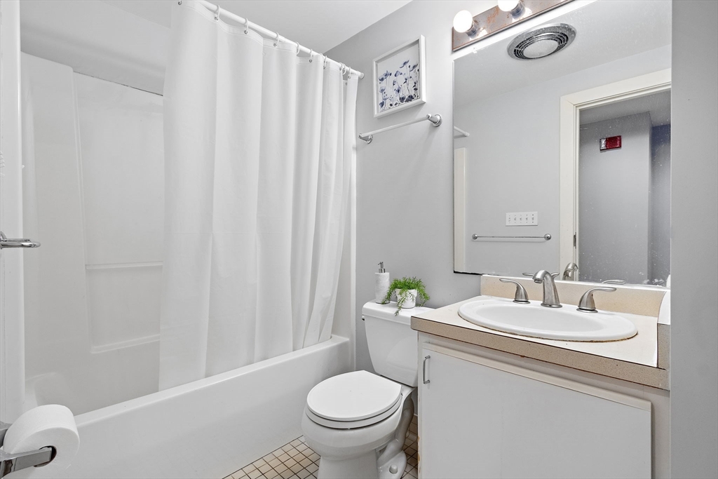 534 Commonwealth Avenue, Unit 3A Boston, MA 02215 - Photo 11 of 18 a bathroom with a granite countertop toilet a sink and a mirror