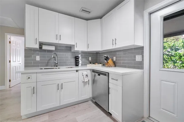 a kitchen with white cabinets and white appliances