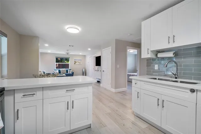 a kitchen with white cabinets appliances and sink