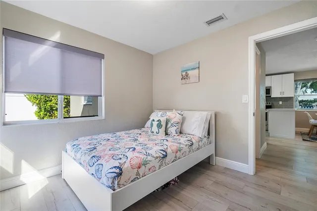 a bedroom with a bed and a view of kitchen