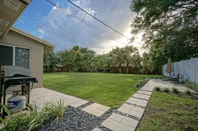 a view of a backyard with table and chairs and potted plants