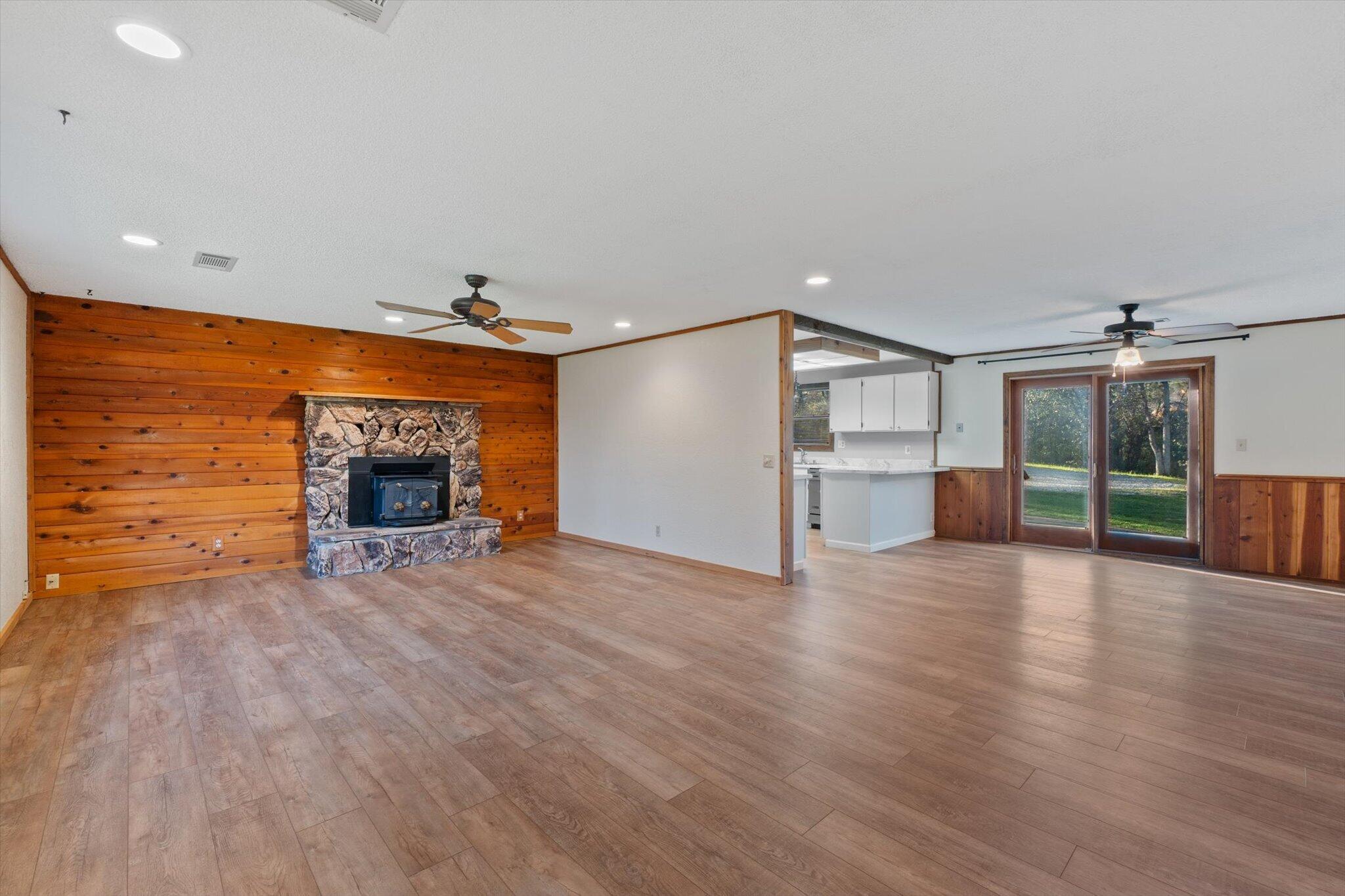 8003 Narrows Way Redding, CA 96001 - Photo 13 of 40 a view of empty room with wooden floor and fireplace
