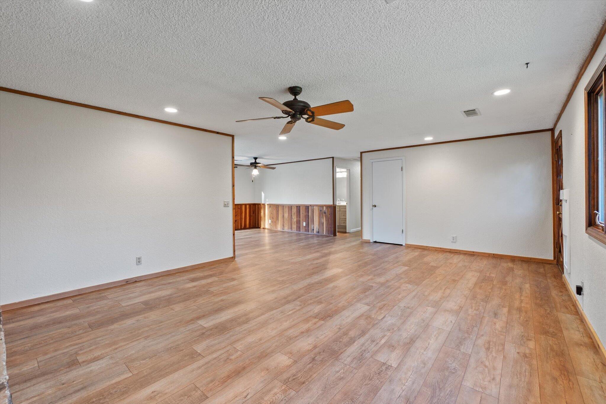 8003 Narrows Way Redding, CA 96001 - Photo 14 of 40 an empty room with wooden floor and a ceiling fan