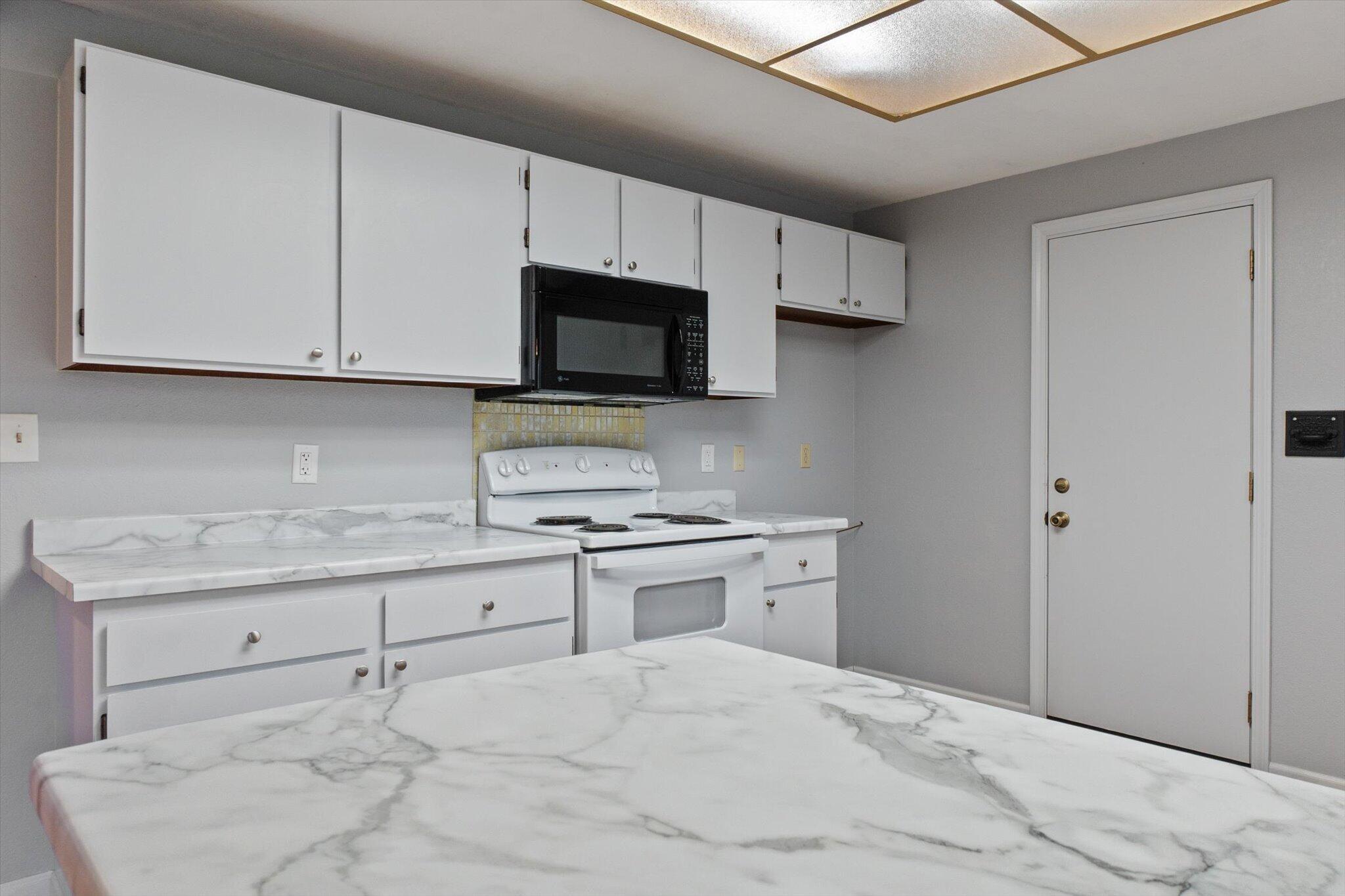 8003 Narrows Way Redding, CA 96001 - Photo 19 of 40 a kitchen with granite countertop a stove sink and microwave