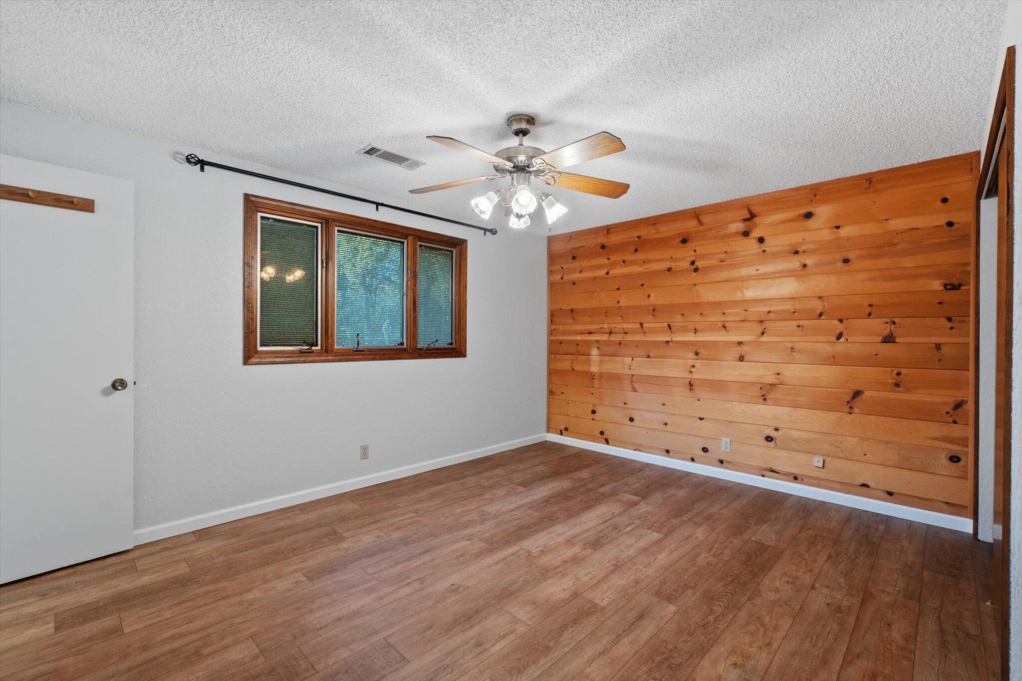 8003 Narrows Way Redding, CA 96001 - Photo 21 of 40 a view of an empty room with wooden floor and a window