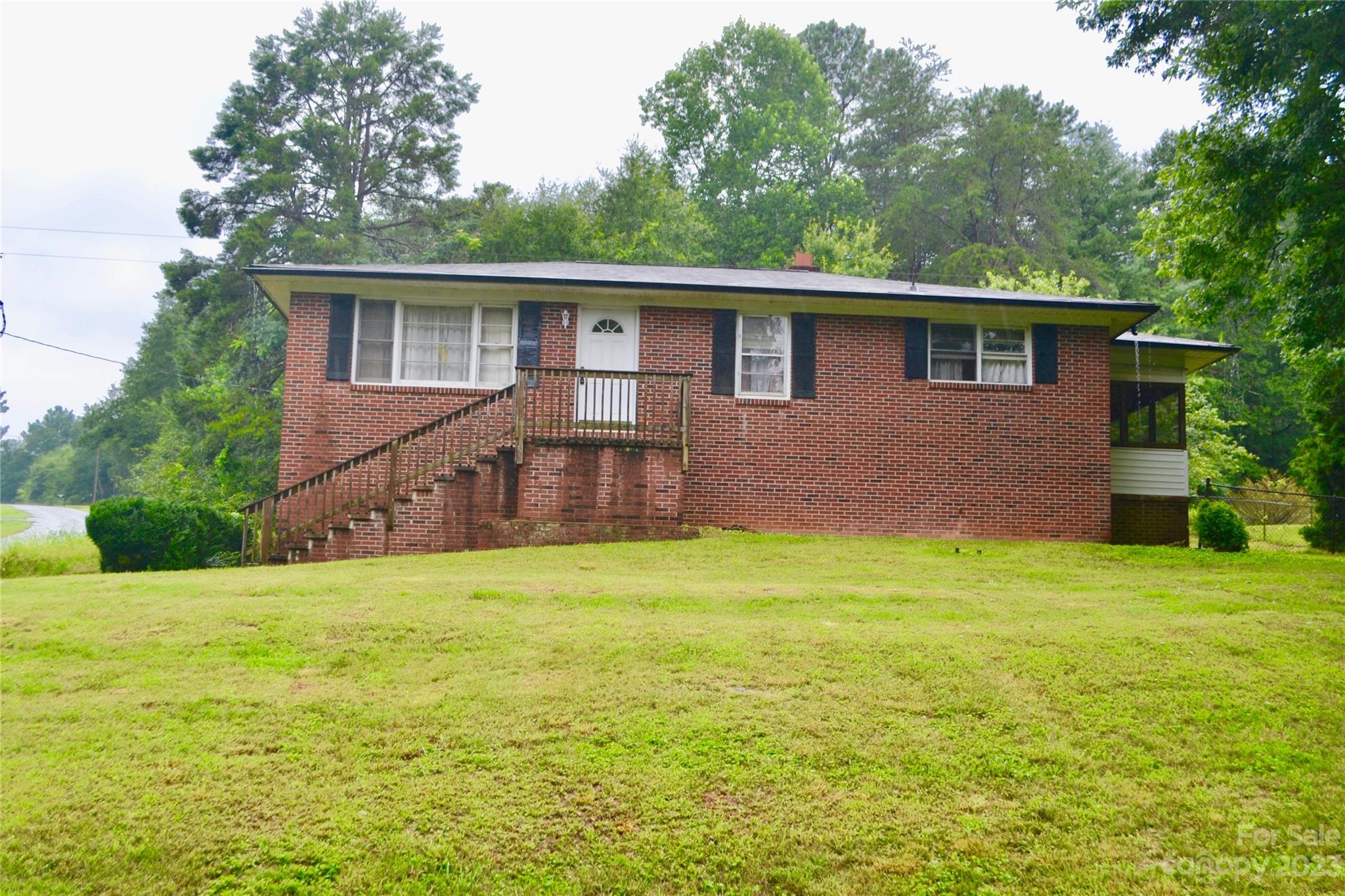 253 Green Acres Road Mooresboro, NC 28114 - Photo 1 of 20 a backyard of a house with large trees and wooden fence