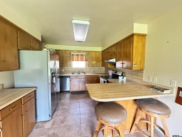 a kitchen with a table chairs and refrigerator