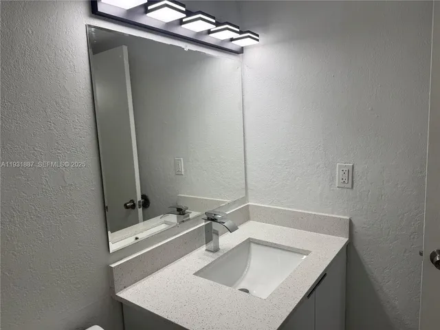 a bathroom with a sink toilet and mirror