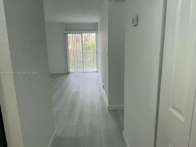 a view of hallway with wooden floor