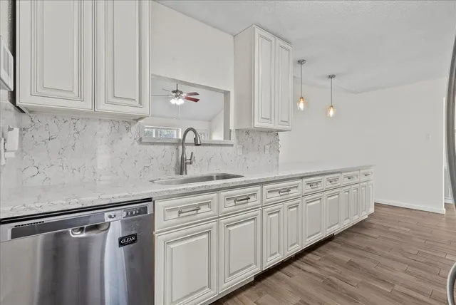 a kitchen with granite countertop white cabinets white appliances and granite countertops with wooden floor
