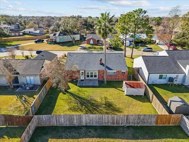 an aerial view of a house with swimming pool lawn chairs and lake view