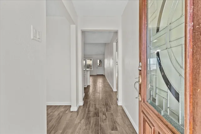 a view of a hallway with wooden floor and staircase