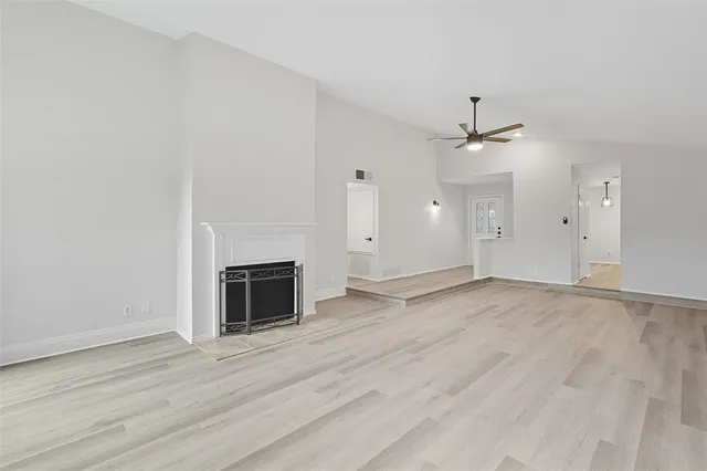 an empty room with a fireplace and wooden floor