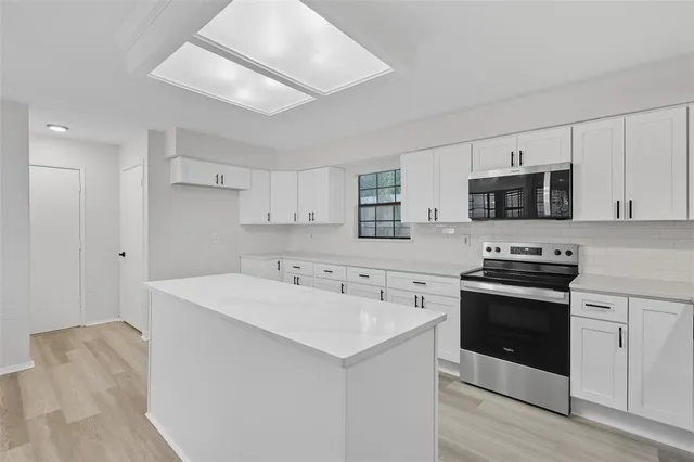 a kitchen with a sink stove and microwave