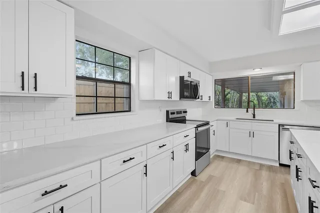 a kitchen with white cabinets and white appliances