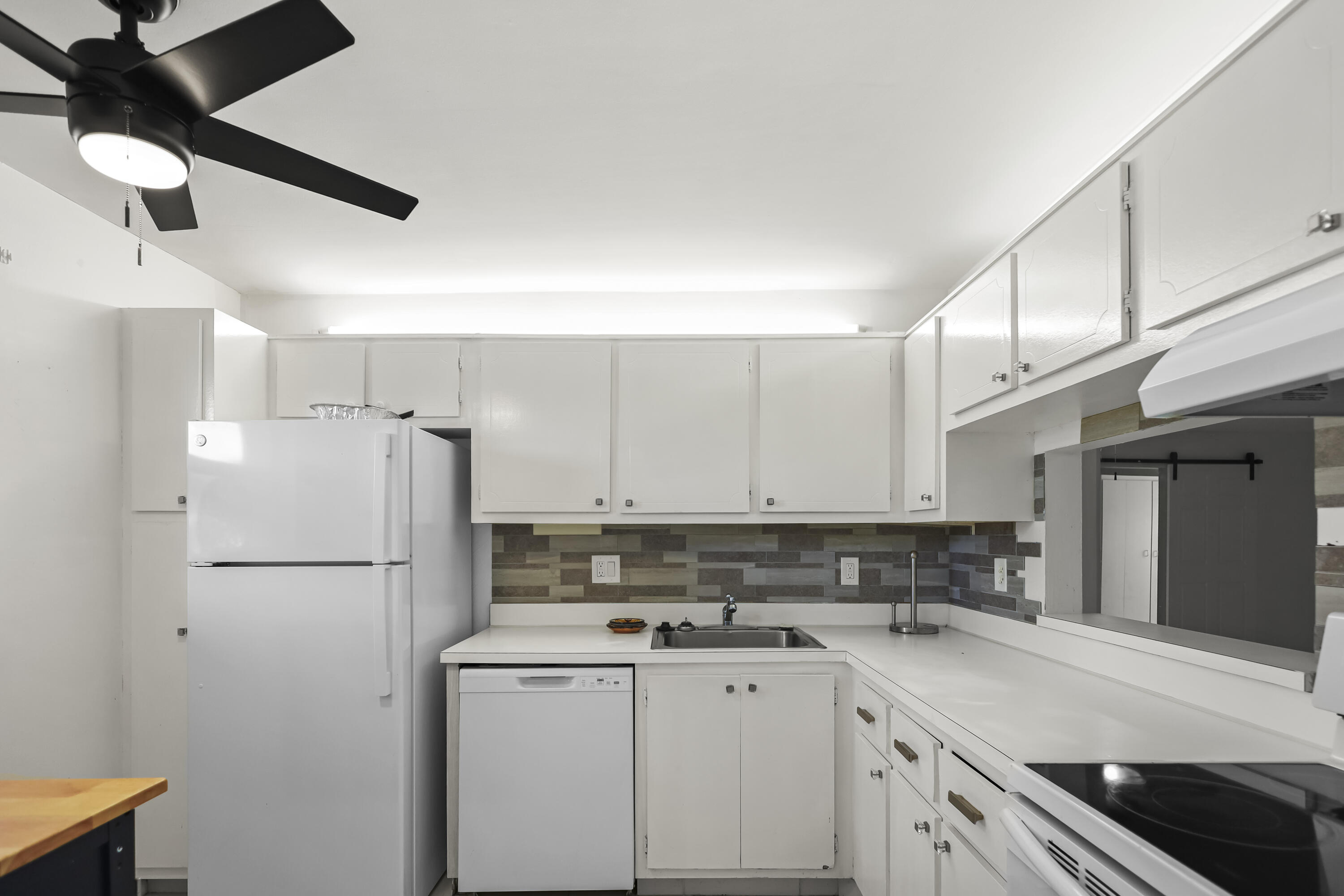 2500 Fiore Way, Unit 103 Delray Beach, FL 33445 - Photo 5 of 19 a kitchen with stainless steel appliances a refrigerator sink and cabinets