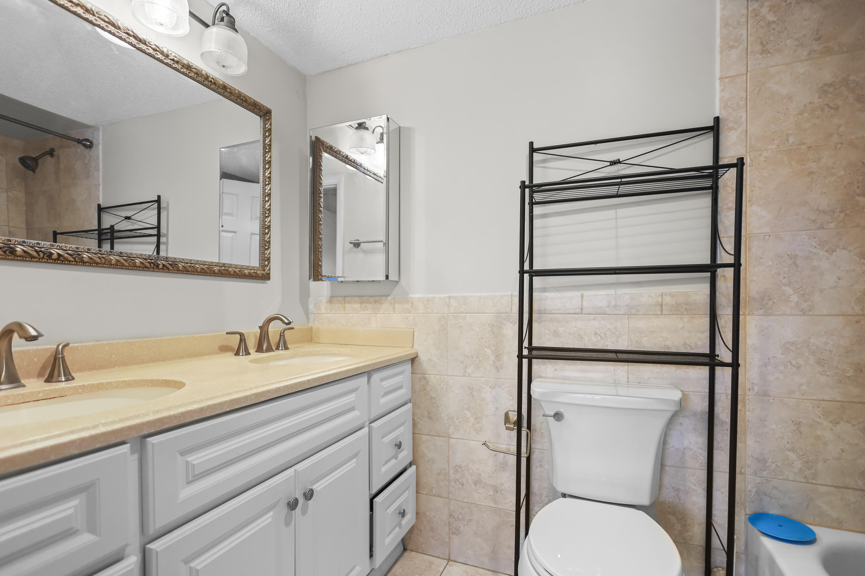 2500 Fiore Way, Unit 103 Delray Beach, FL 33445 - Photo 10 of 19 a bathroom with a toilet sink and mirror