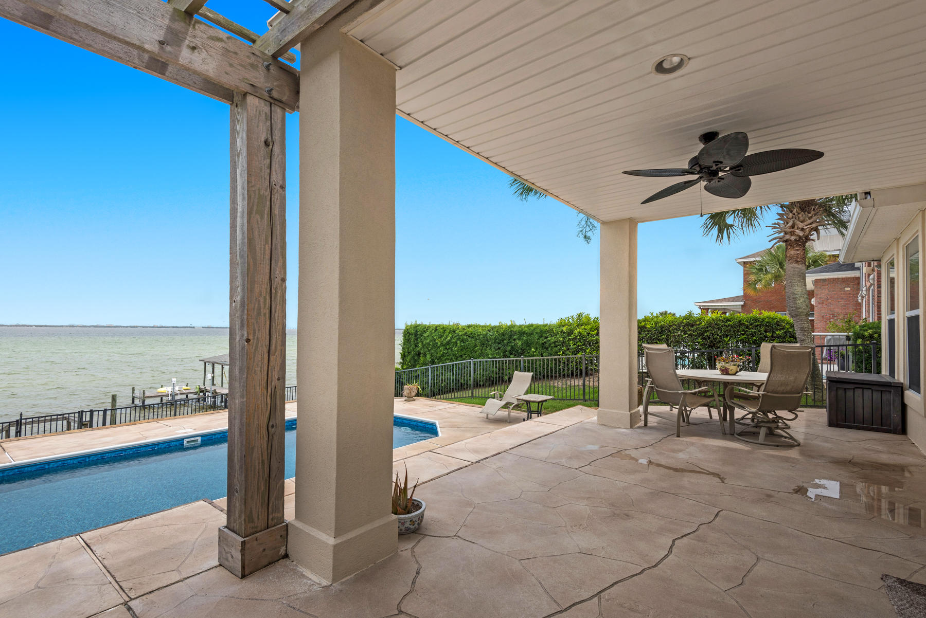 311 Country Club Road Shalimar, FL 32579 - Photo 58 of 73 a view of a terrace with a floor to ceiling window and a table under an umbrella