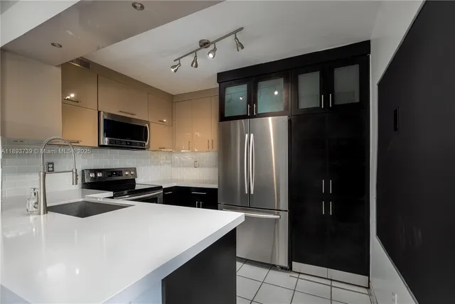 a kitchen with a sink a refrigerator and a stove top oven