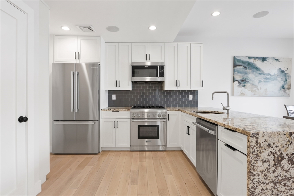 309 E Street, Unit 45 Boston, MA 02127 - Photo 5 of 33 a kitchen with granite countertop stainless steel appliances and wooden cabinets