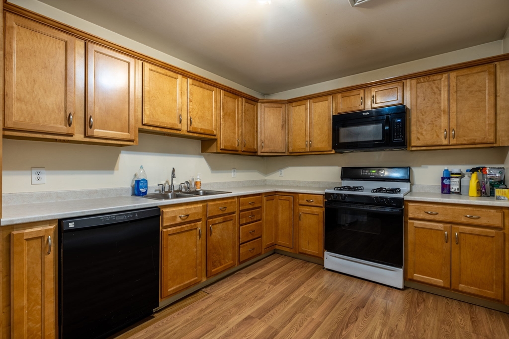 1556 North Main Street, Unit 10 Fall River, MA 02720 - Photo 8 of 30 a kitchen with granite countertop wooden cabinets and a stove top oven