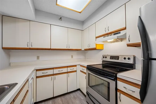 a kitchen with white cabinets and white appliances