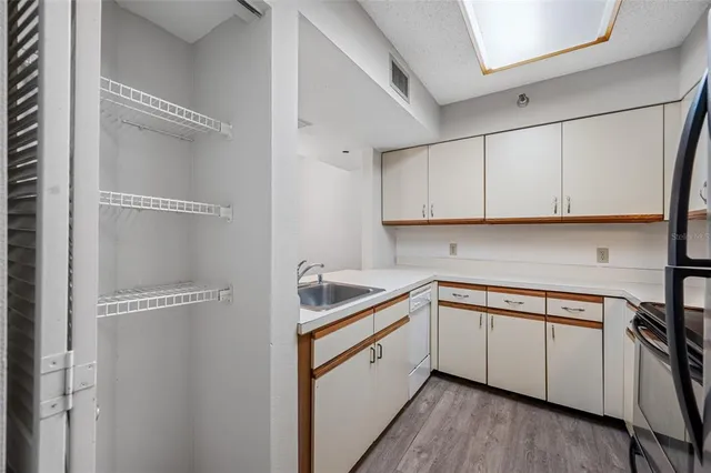 a kitchen with white cabinets and white appliances