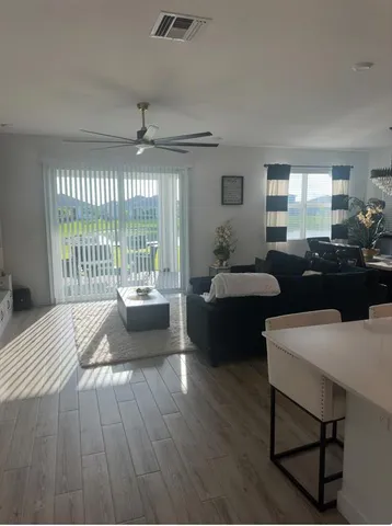 a living room with furniture and a floor to ceiling window