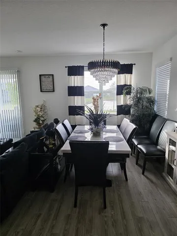 a dining room with furniture a chandelier and wooden floor