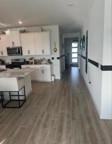a kitchen with a sink and wooden floor