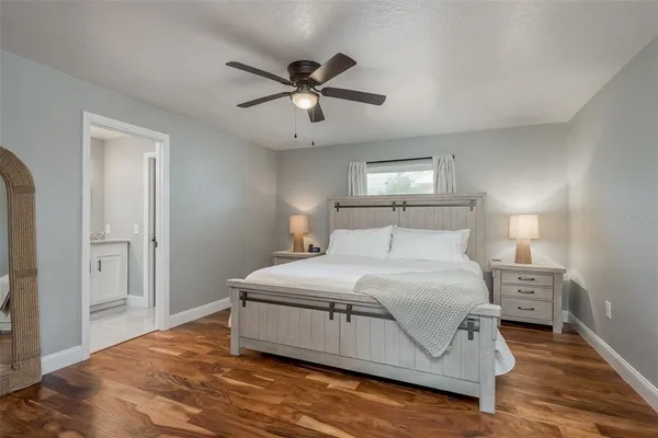 a bedroom with a bed and wooden floor