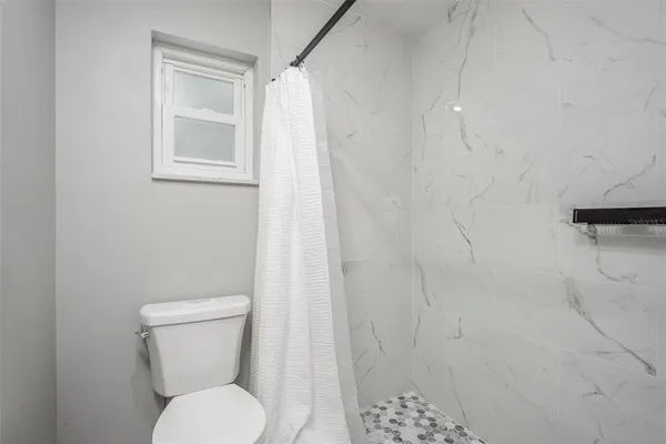 a white toilet sitting next to a shower